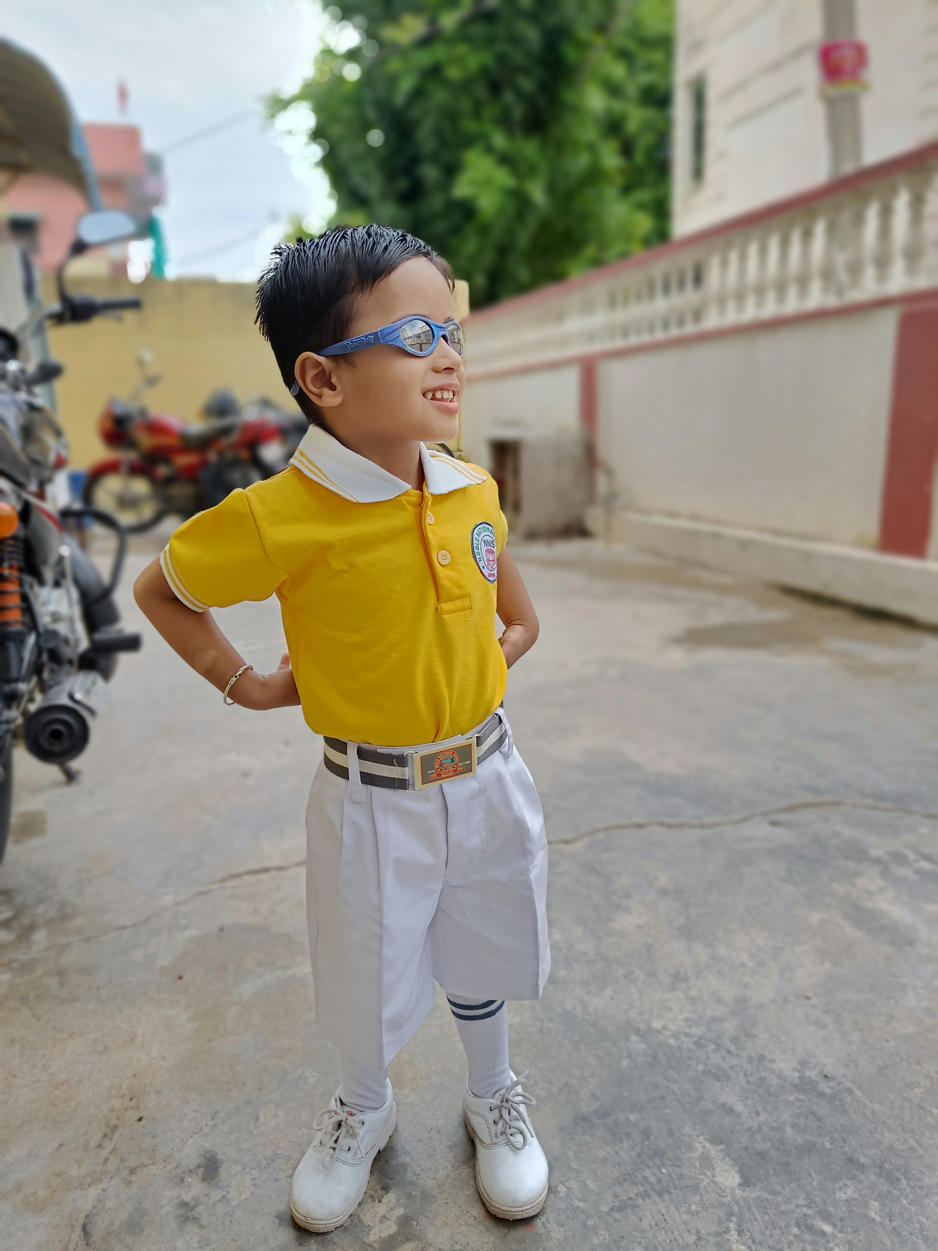 a boy wearing a yellow shirt and white pants
