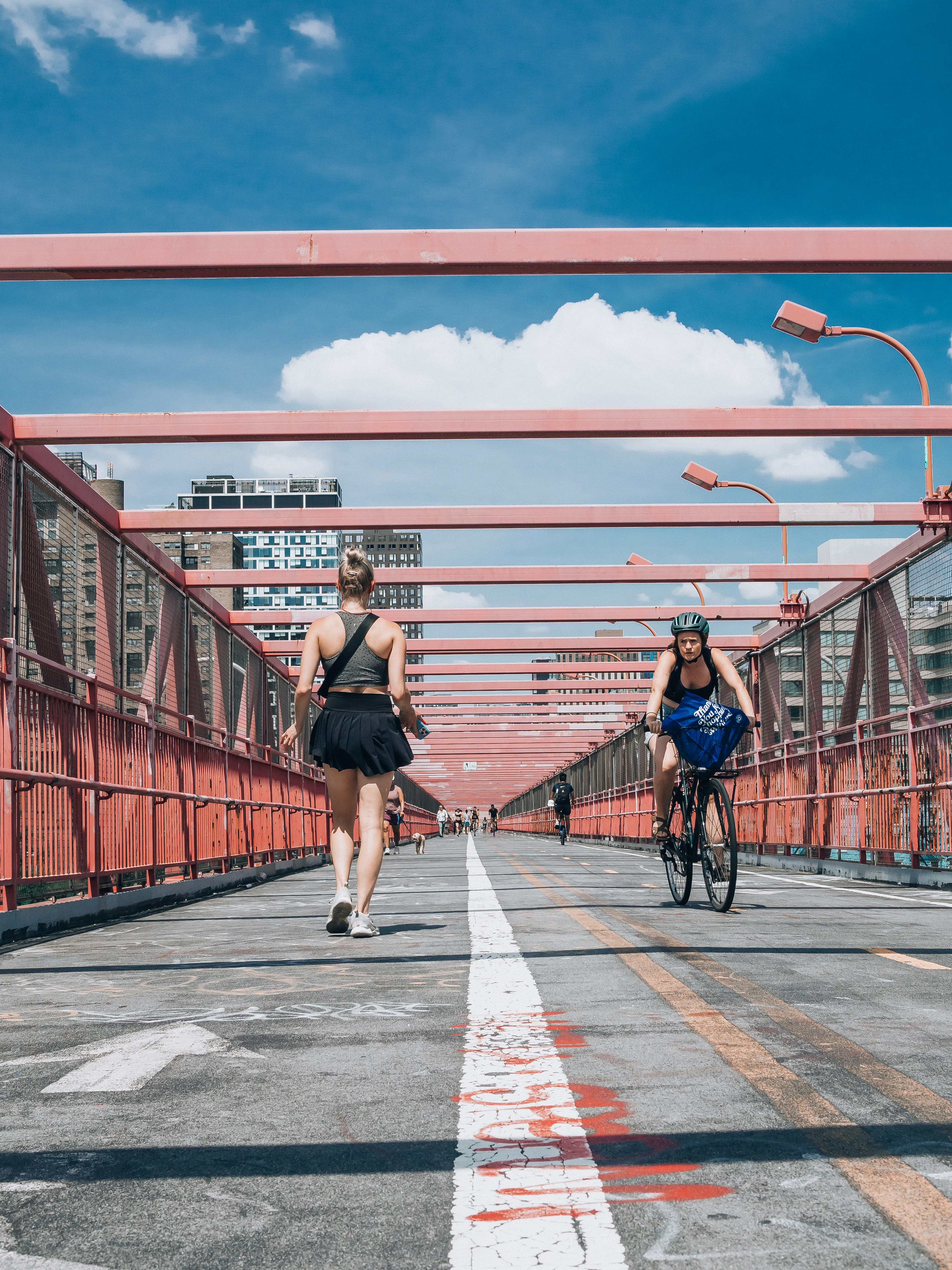 a couple of women riding bikes on a bridge