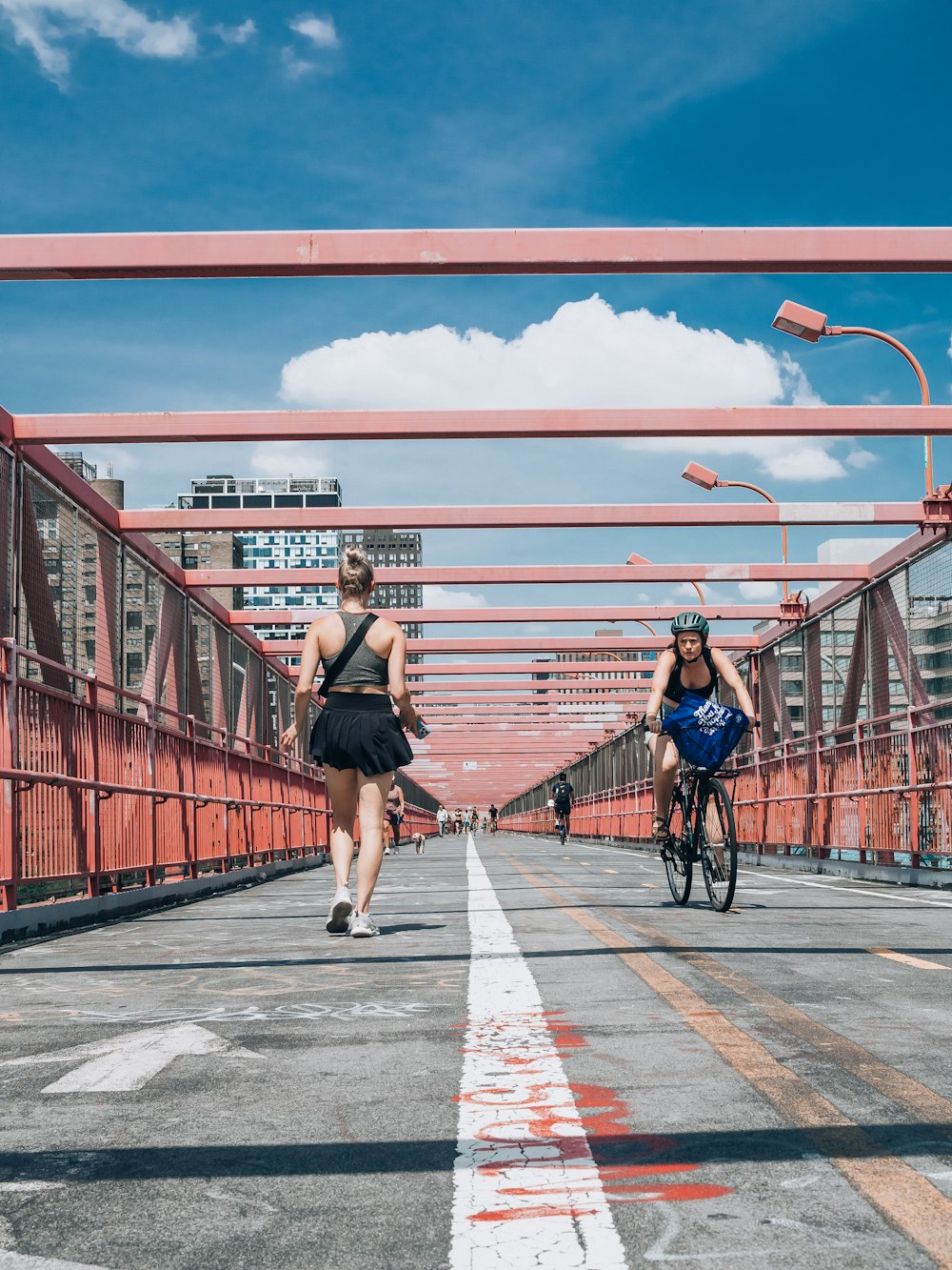 a couple of women riding bikes on a bridge