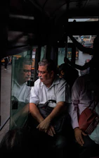 Experienced driver helping a family with luggage beside a clean, spacious tempo traveller.