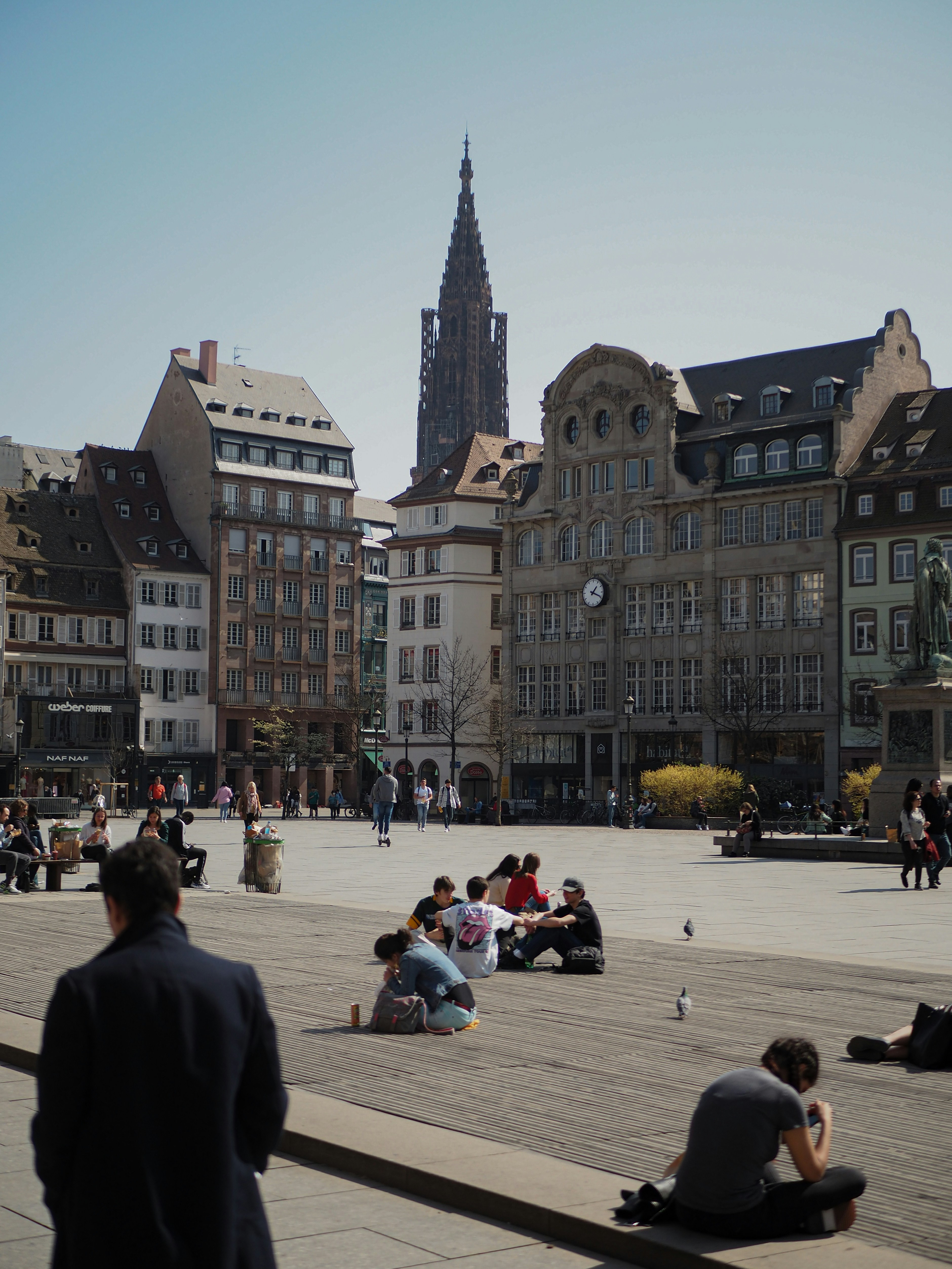 Un groupe de personnes assises par terre devant un grand bâtiment photo ...