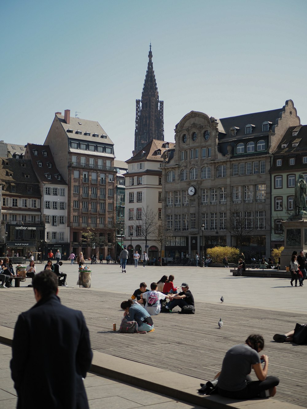 un gruppo di persone sedute per terra di fronte a un grande edificio