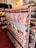 A display of various rolls of fabric on a rack, with patterns ranging from a world map to geometric and floral designs. A yellow sign above reads 'TELA RESINADA 6.50€ 1.40 ANCHO'. The setting appears to be a fabric store with shelves filled with different types of fabric.