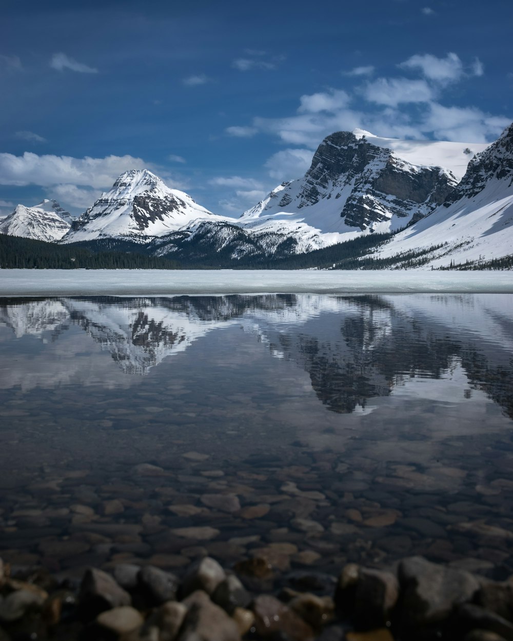 a lake with snowy mountains in the background