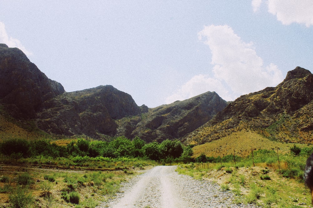 a dirt road in a valley between mountains