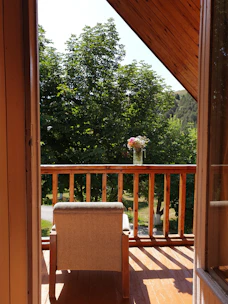 A private balcony with outdoor seating overlooking a serene garden.