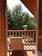 A cozy villa balcony overlooking a lush garden with vibrant flowers.