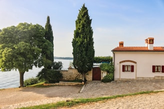 a building with trees and a body of water in the background