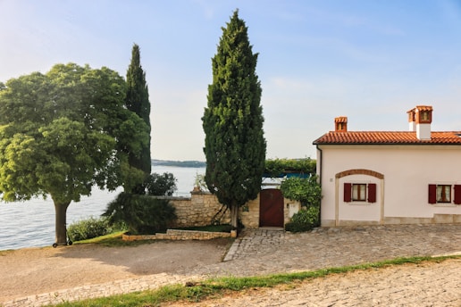 a building with trees and a body of water in the background