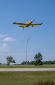 Drone flying low over a green agricultural field spraying crops.