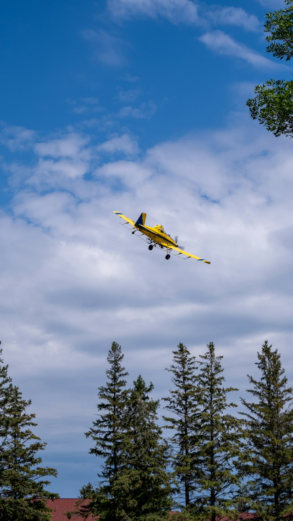 a yellow plane flying through the air