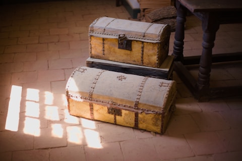 a couple of large wooden chests on a tile floor