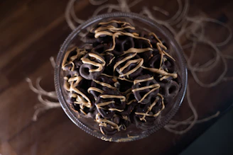 Close-up of chocolate dipped pretzels decorated with colorful sprinkles and delicate drizzles.
