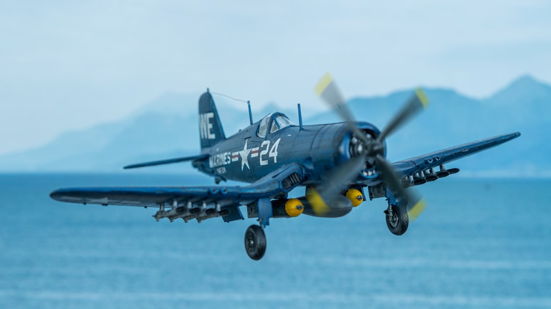 a plane flying over water, Diorama of a F4U Corsair scale model flying over the sea.