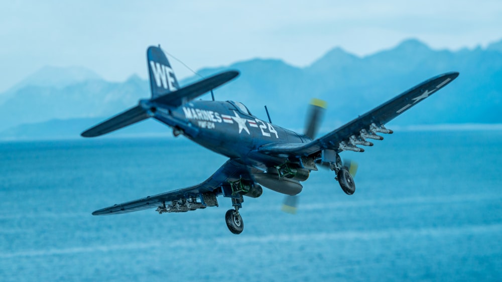 a military plane flying over water