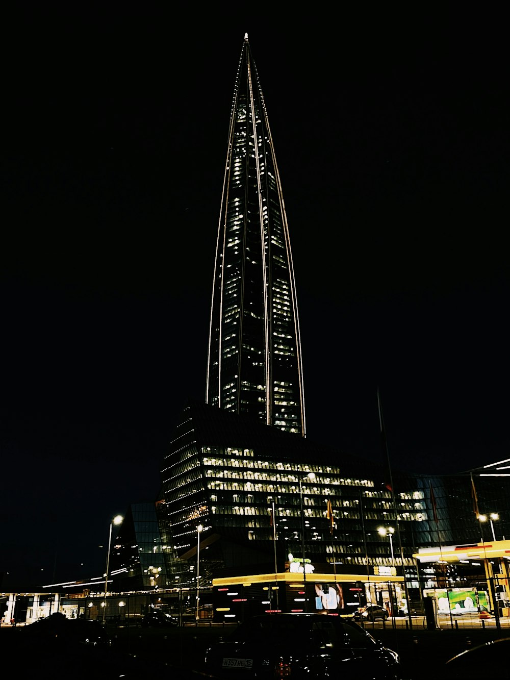 a tall tower lit up at night with Torre del Reformador in the background