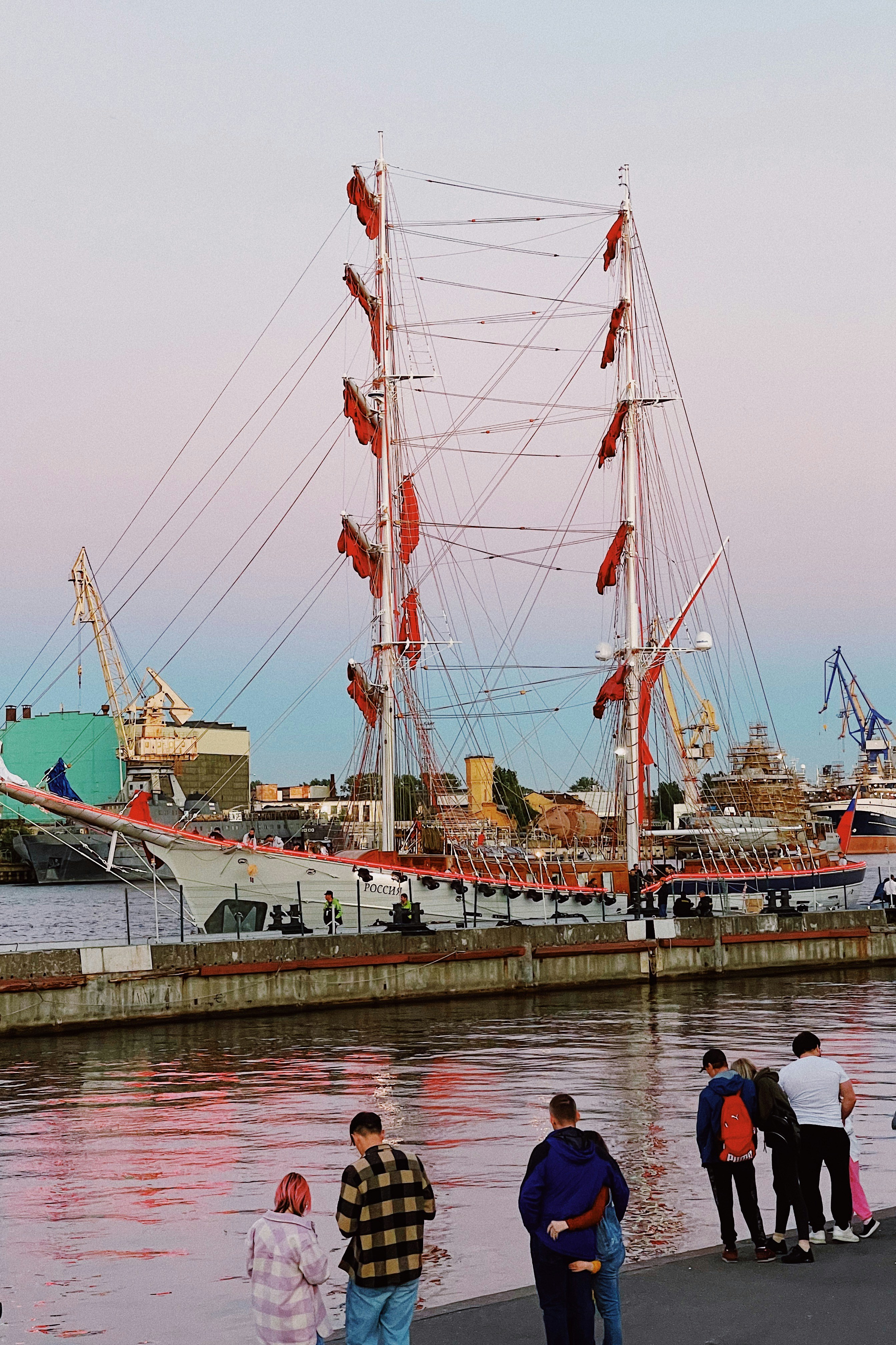 a group of people standing next to a large ship