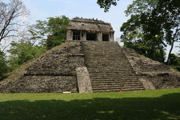 A stone building with steps with Palenque in the background