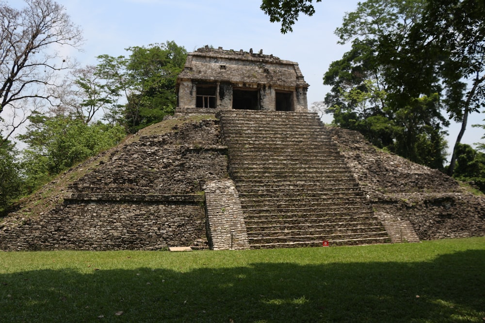 a stone building with steps with Palenque in the background