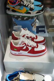 Stacked sneakers in vibrant colors resting on a graffiti-covered stairway.