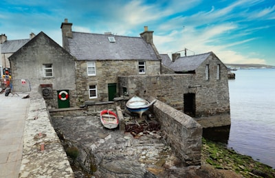 a stone building next to a body of water