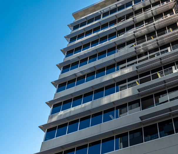 A commercial office building with clean lines and large windows under a bright blue sky