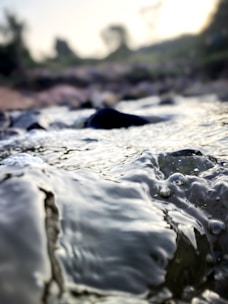 Close-up of pure water flowing in a natural stream, symbolizing purification and renewal.
