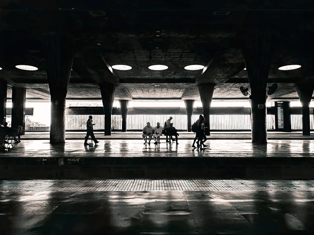 people sitting on benches in a large building