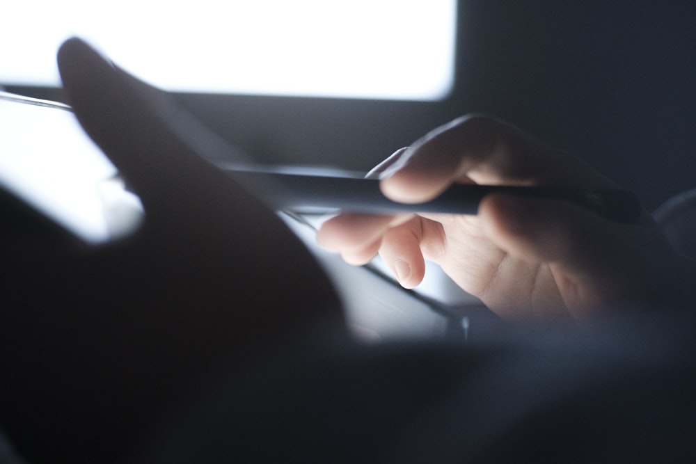 a hand holding a laptop