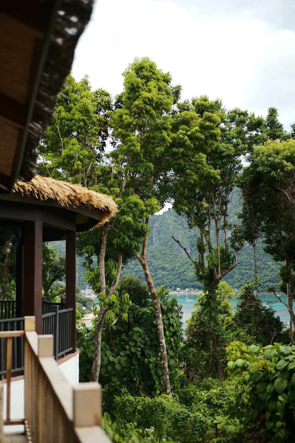 a house with trees and a body of water in the background