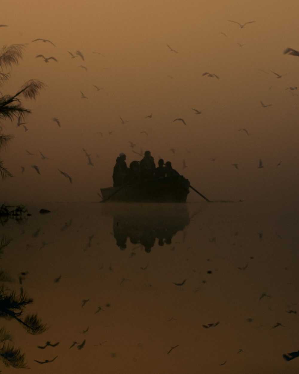 a boat in the water with birds flying around