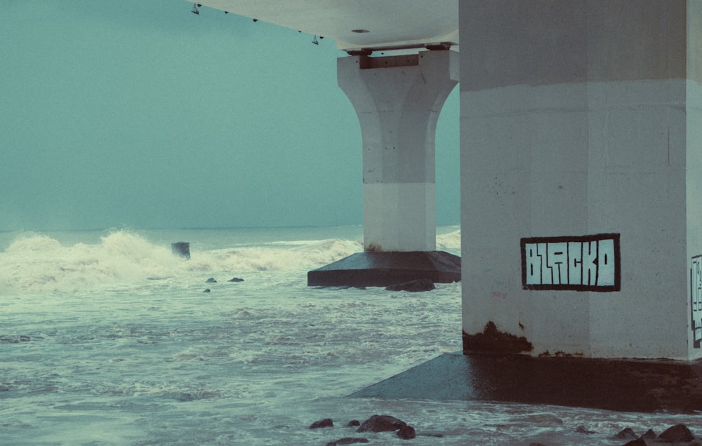 a large wave crashing into a concrete wall