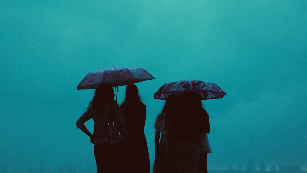 people holding umbrellas in the rain