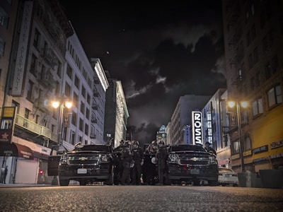 A city street at night with police cars and flashing lights.