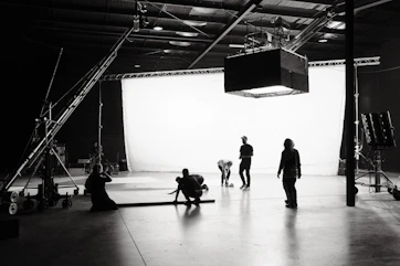 Behind-the-scenes shot of a film crew setting up lighting equipment in a home studio.