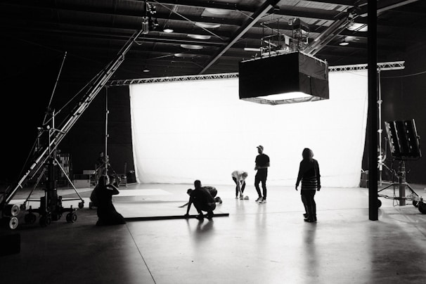 A creative team collaborating over storyboards and camera equipment in a bright studio.