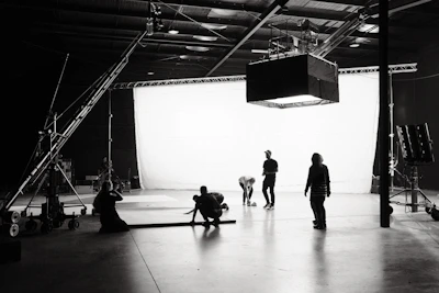 A cinematic still showing the altélo studio team collaborating in a softly lit, minimalist workspace.