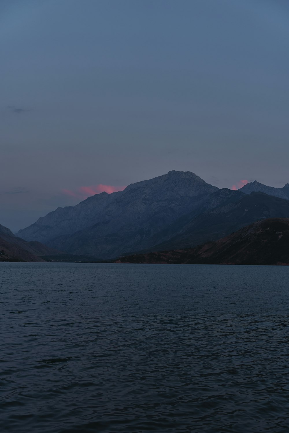 a body of water with mountains in the background