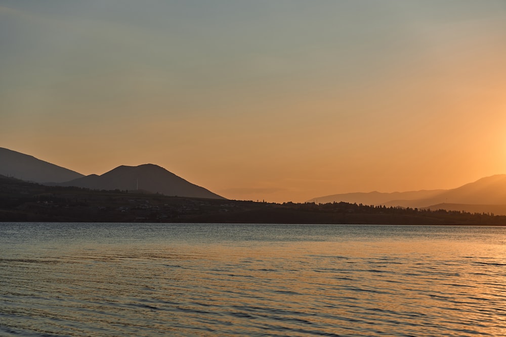 a body of water with mountains in the background