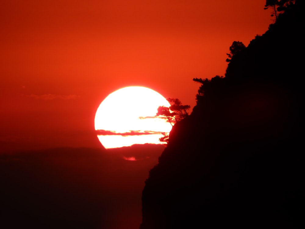 a silhouette of a person looking at a sunset