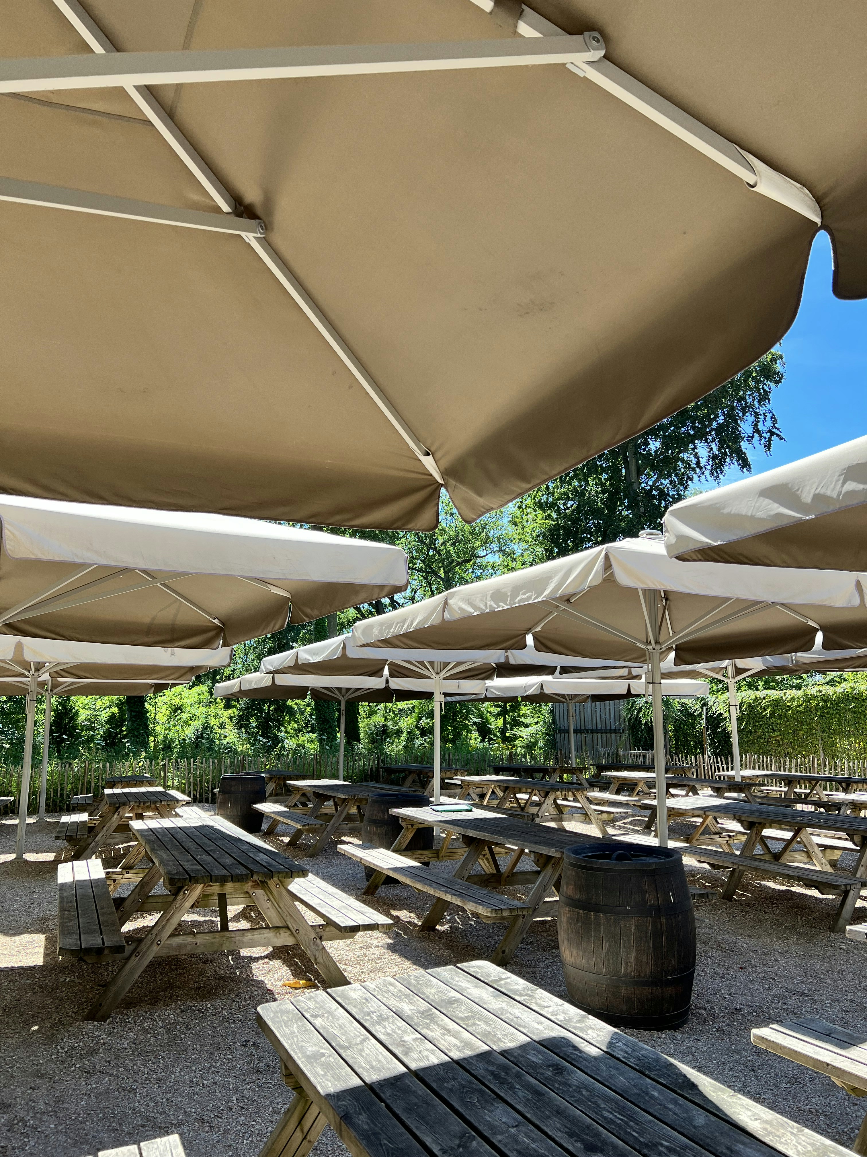 um grupo de mesas e cadeiras sob guarda-sóis brancos