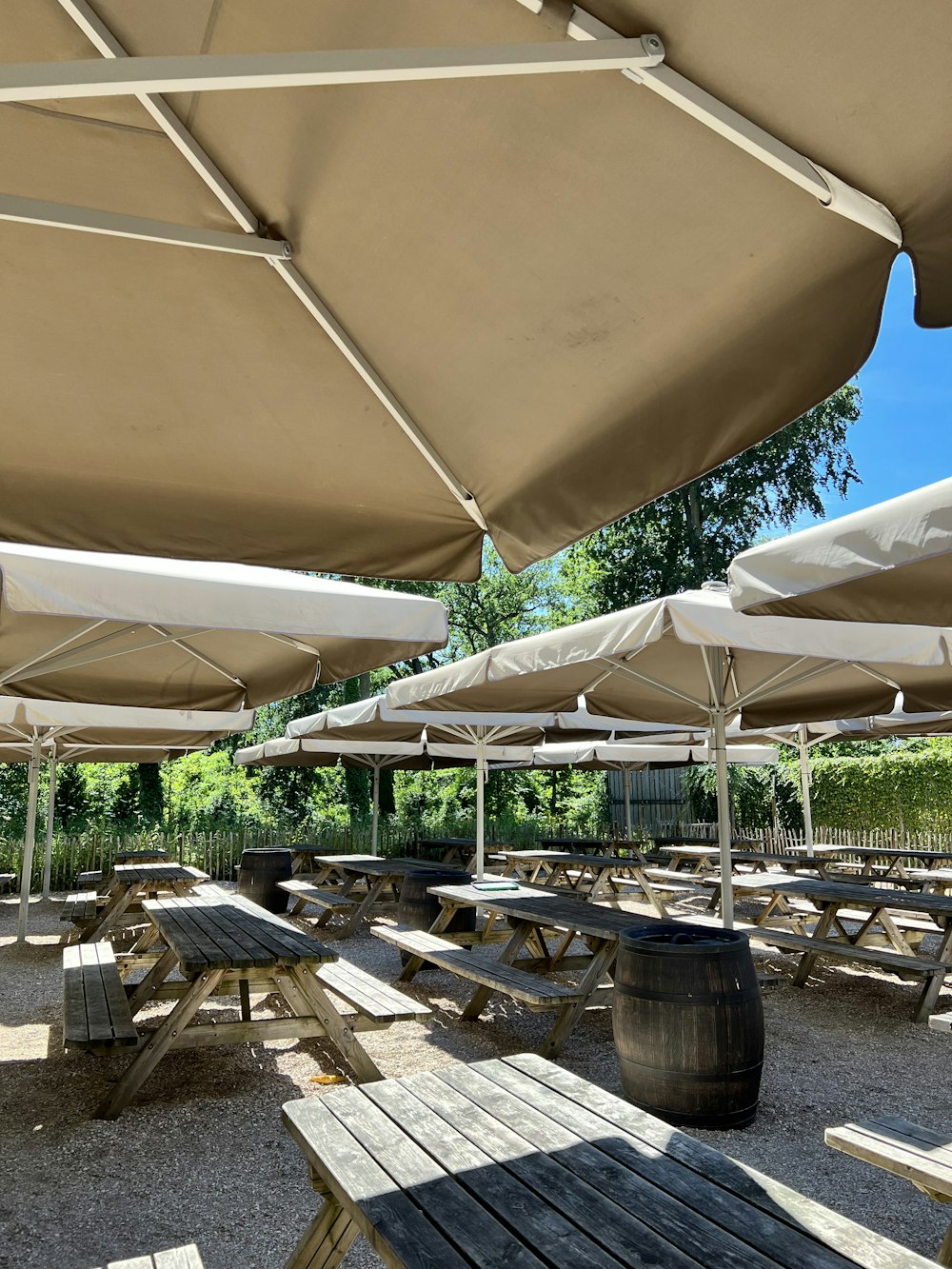 a group of tables and chairs under white umbrellas