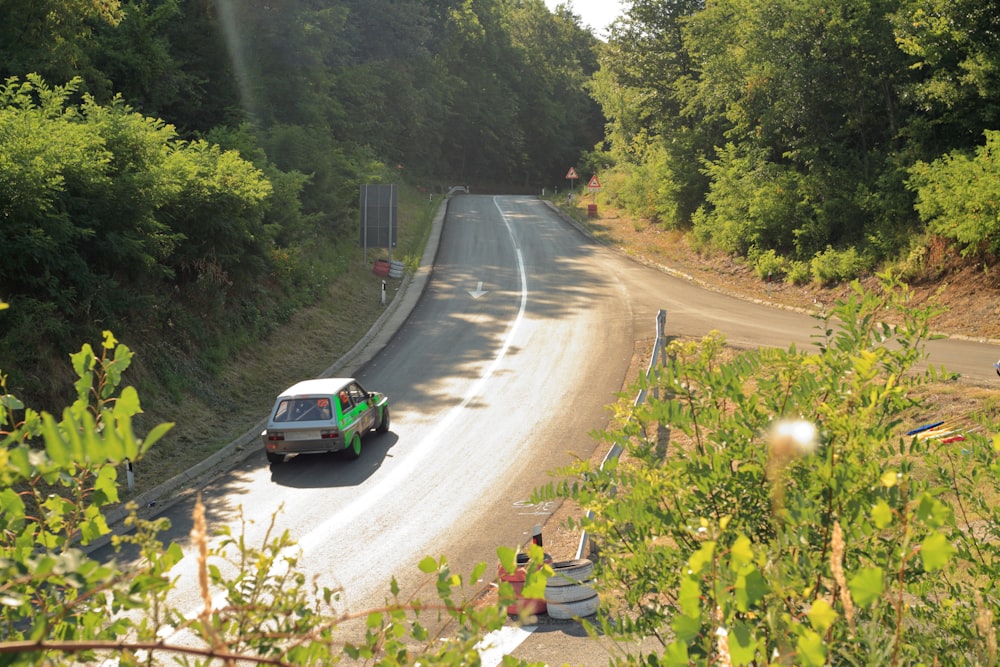 a car on a road with trees on the side