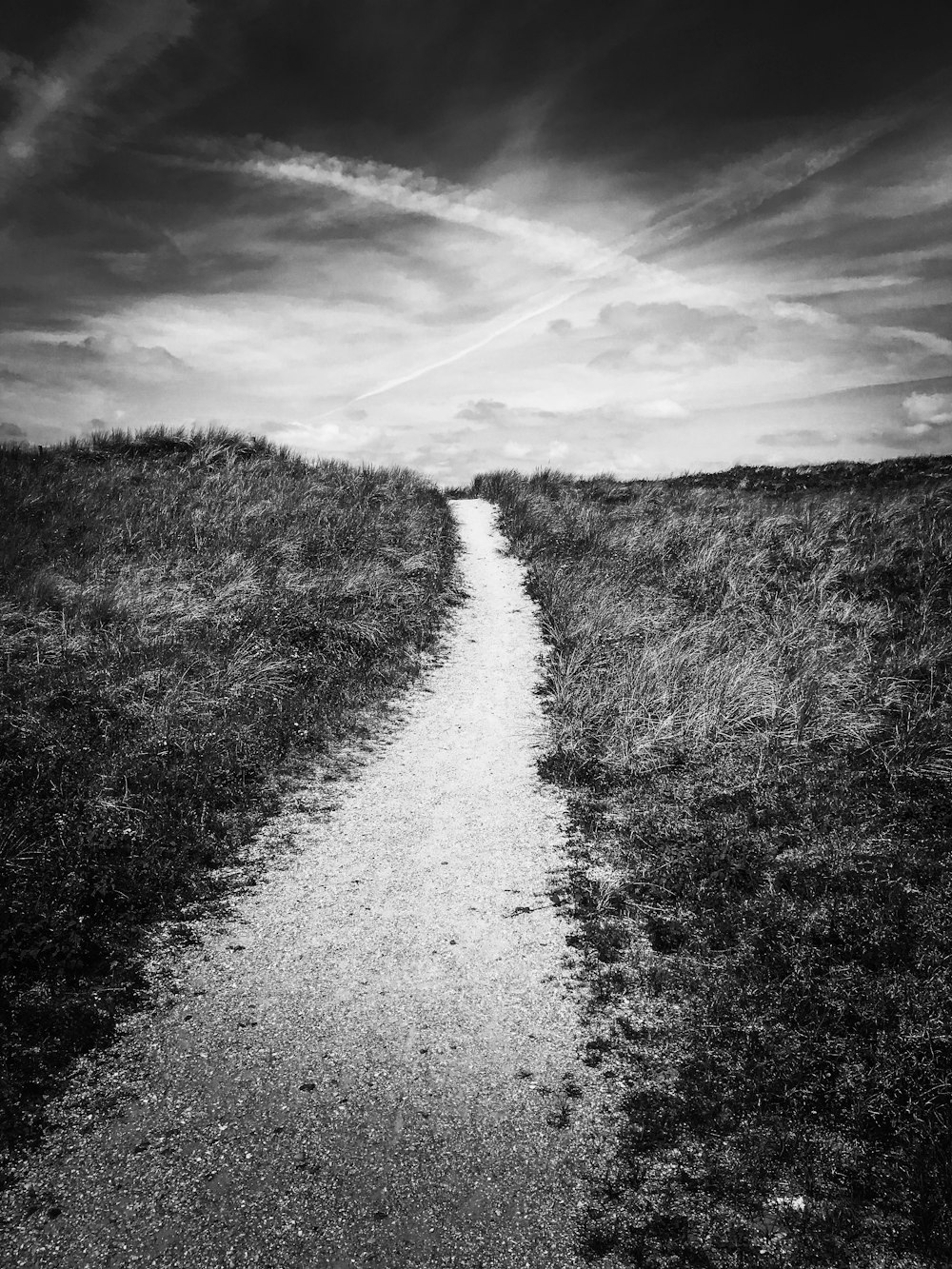 a dirt road with grass on either side of it