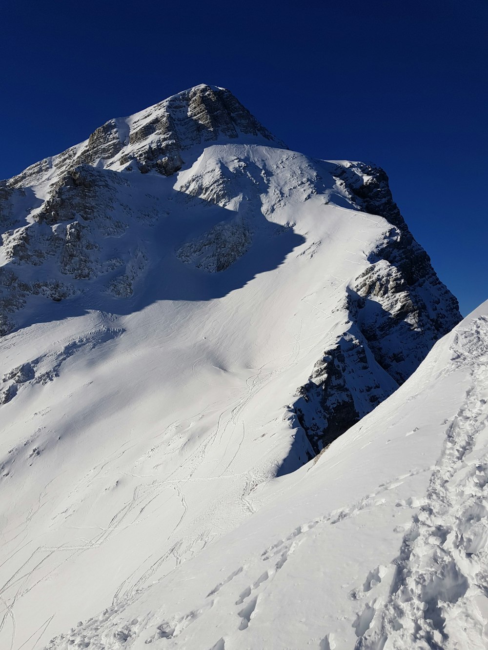 a snowy mountain with a blue sky