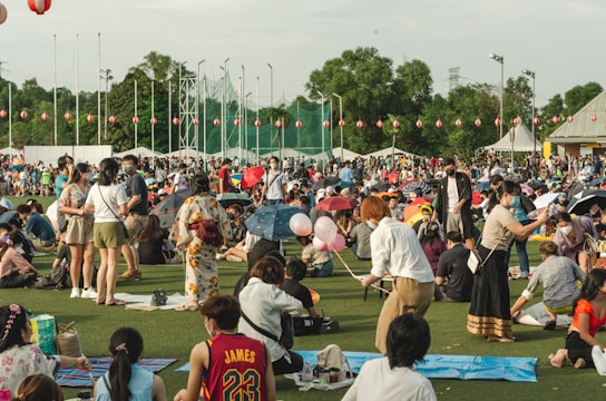 a group of people dancing in a field with a crowd watching