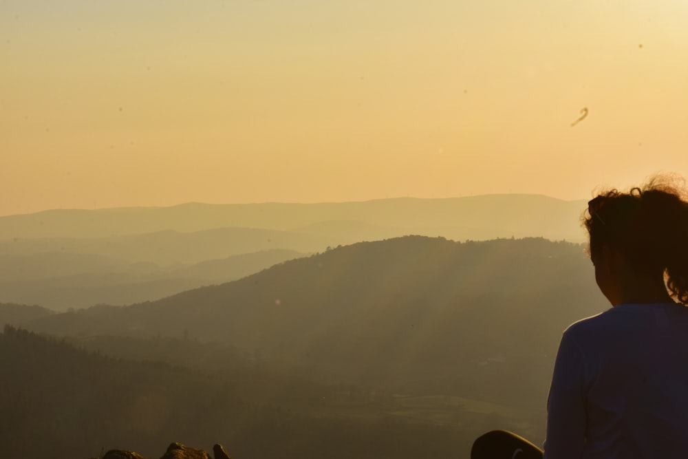 a person looking at a plane flying in the sky