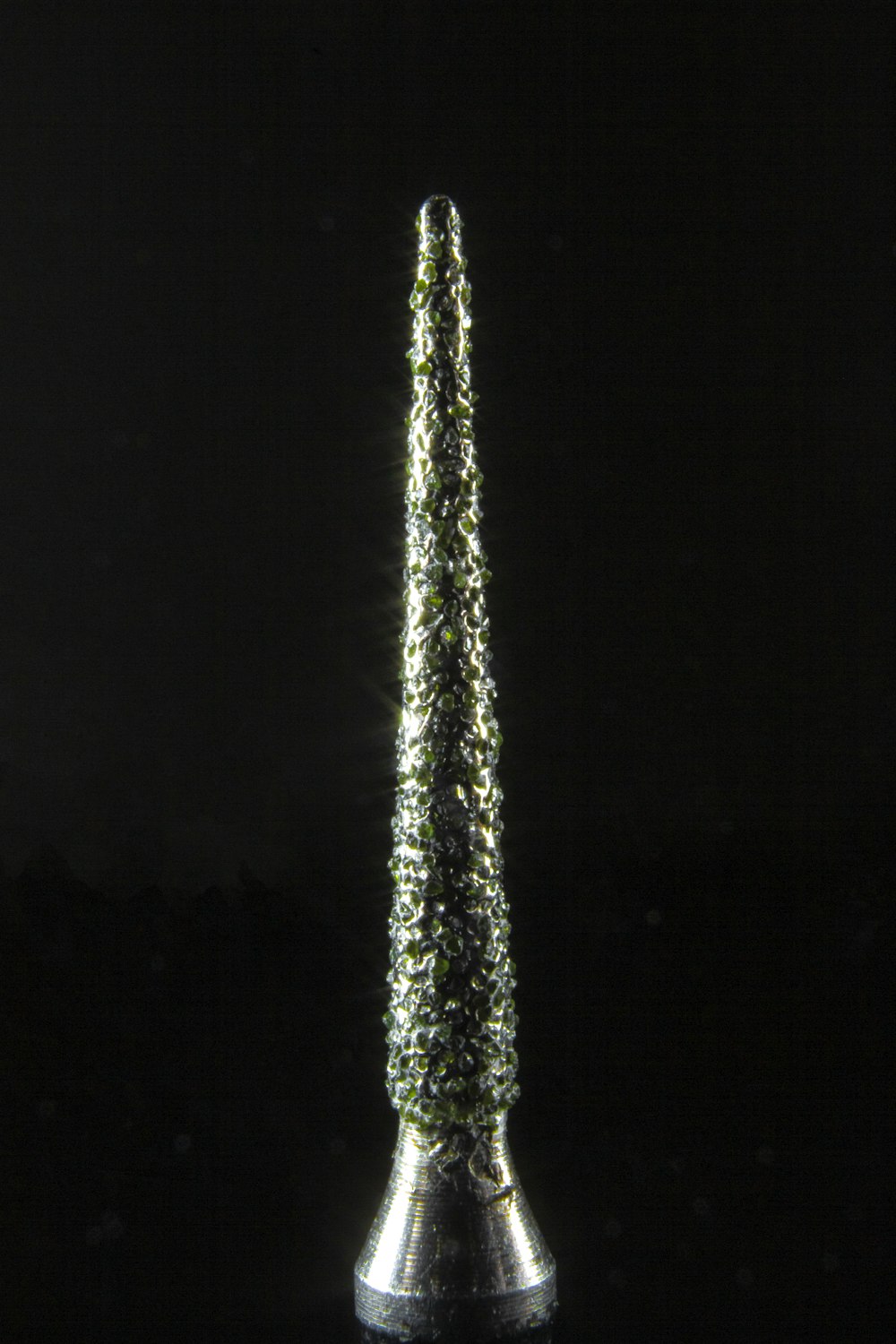 a tall pointy tower with green lights