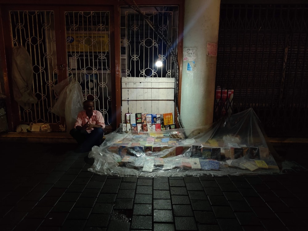 a person sitting on the ground next to a pile of items