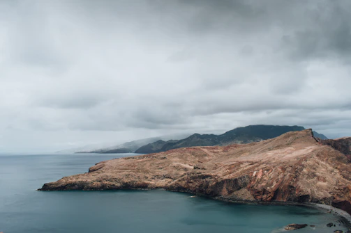 Wide shot of Baja's rugged coastline under dramatic skies.